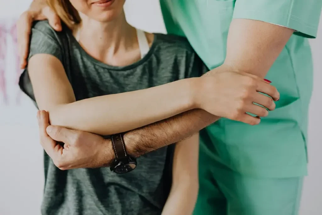 Fysioterapeutti mobilisoi ja venyttää potilaan olkapäätä ”jäätyneen olkapään” tai muun liikerajoituksen hoitamiseksi. Fysioterapeutti mobilisoi ja venyttää potilaan olkapäätä "jäätyneen olkapään" tai muun liikerajoituksen hoitamiseksi.