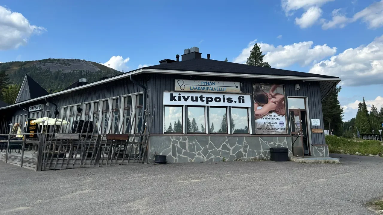 Ulkokuva Pyhätunturin toimipisteestä, jossa näkyy kyltti ja tilava pysäköintialue asiakkaille. Ulkokuva Pyhätunturin toimipisteestä, jossa näkyy kyltti ja tilava pysäköintialue asiakkaille.